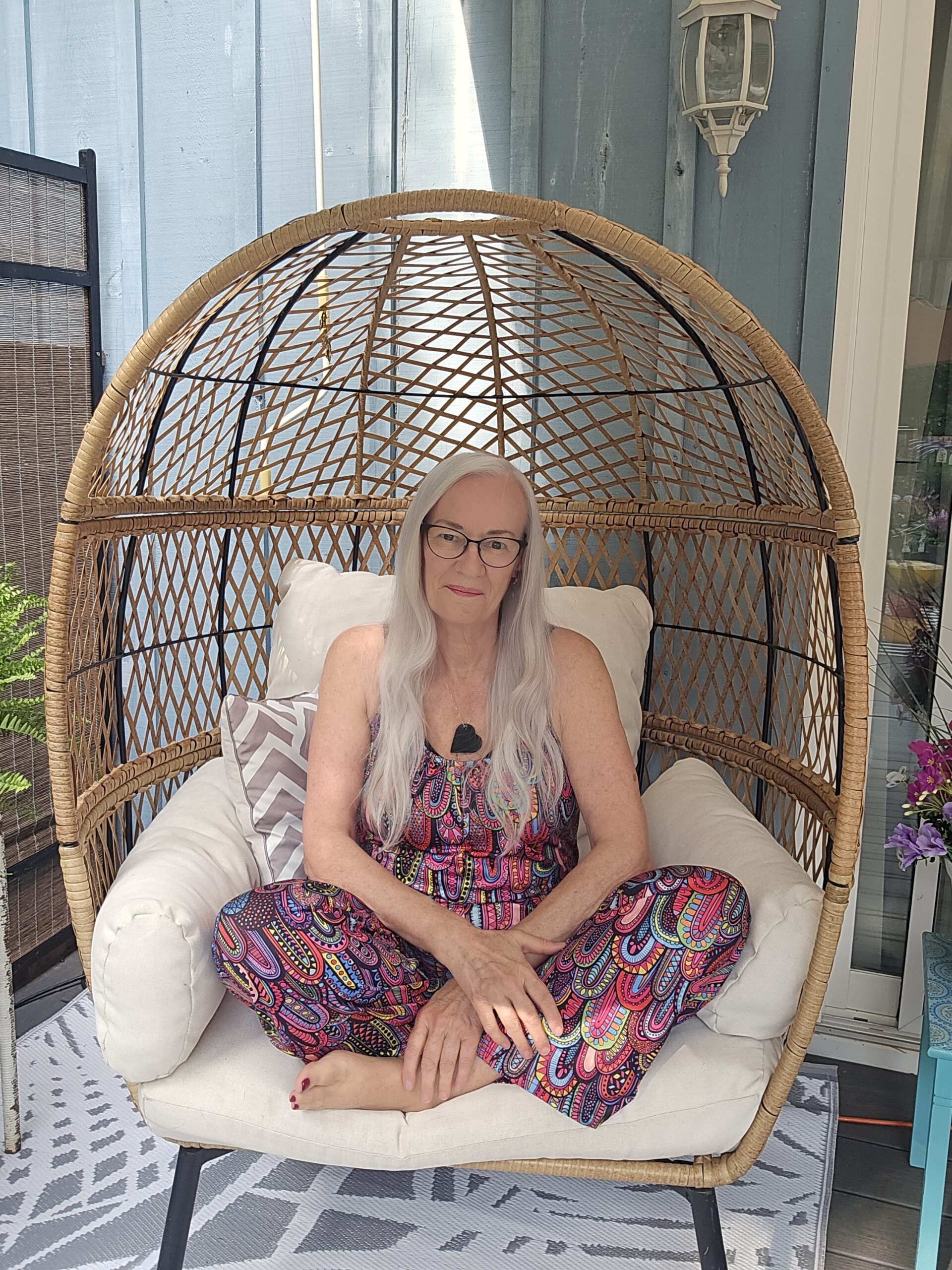 Judy sitting cross-legged and relaxed in a hanging egg chair